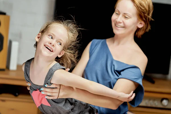 Schöne kleine Tochter mit Mama posiert im Studio auf grauem Hintergrund — Stockfoto
