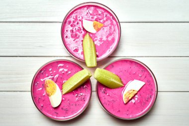 Beyaz masada lezzetli soğuk Pancar çorbası ile üç cam kase.