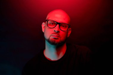 Neon ışık arka planda gözlüklü sakal ile çekici kel adam