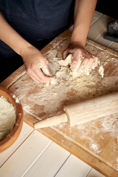 Kadın ahşap masada un ve haddeleme pin ile pasta tahtası üzerinde hamur hazırlar — Stok fotoğraf