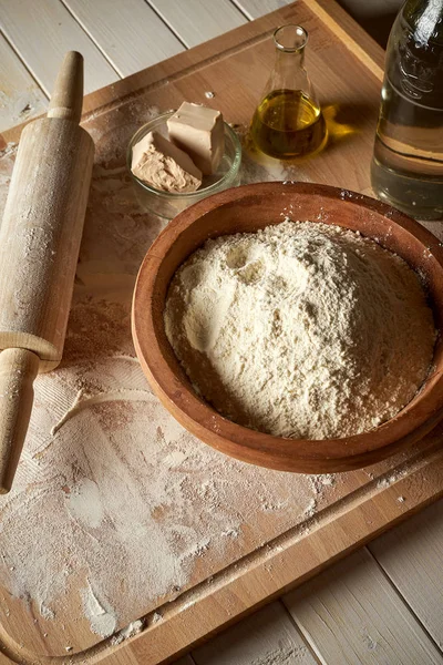 Masa üzerinde un ve haddeleme pin ile pasta tahtasında hamur için malzemeler — Stok fotoğraf