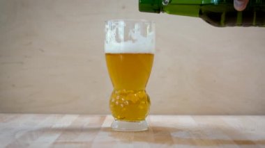 Mans el bir şişe tutuyor ve bir cam içine bira damlar