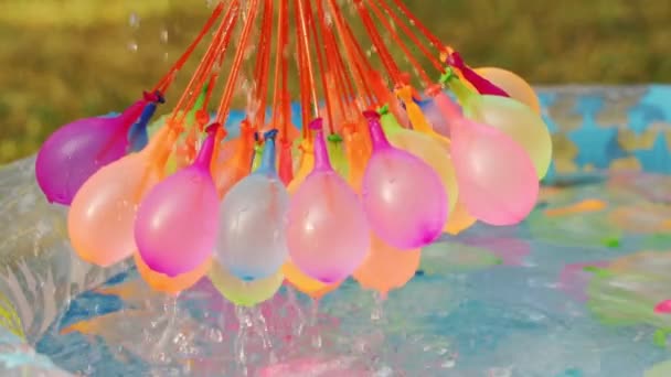 Close-up van kleurrijke water ballonnen gevuld met water op zomerdag — Stockvideo