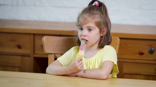 Piękna dziewczynka jedzenia pyszne kolorowe lody — Wideo stockowe