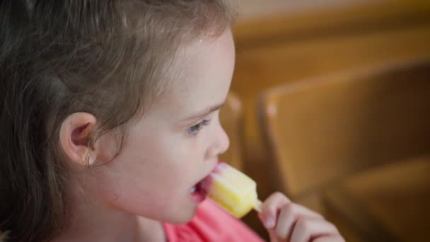 Gyönyörű kislány eszik egy finom színes fagylalt — Stock videók
