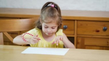 bir kalem ile sarı bir elbise küçük kız kağıt üzerinde berabere