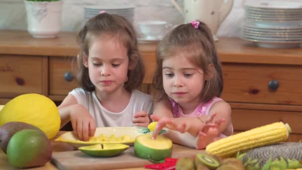 Két aranyos lányok nevetnek, és eszik a Juicy sárga Mango — Stock videók