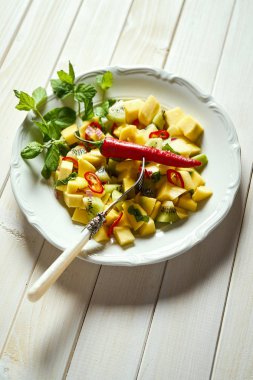 Beyaz ahşap masada kavun ile taze organik renkli salata