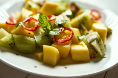 Beyaz ahşap masada kavun ile taze organik renkli salata