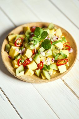 Beyaz ahşap masada kavun ile taze organik renkli salata