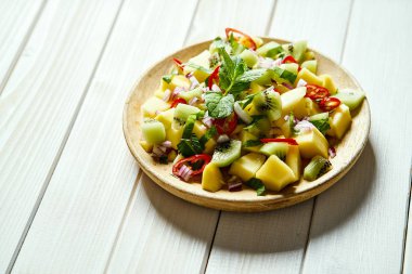 Beyaz ahşap masada kavun ile taze organik renkli salata