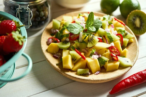 Salade fraîche et colorée de melon bio au chili sur table blanche — Photo
