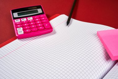 damalı sayfalar ve hesap makinesi ve kalem ile açık defter