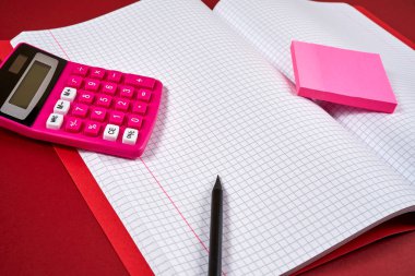 damalı sayfalar ve hesap makinesi ve kalem ile açık defter