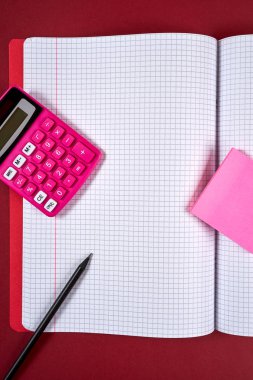 damalı sayfalar ve hesap makinesi ve kalem ile açık defter