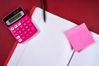 damalı sayfalar ve hesap makinesi ve kalem ile açık defter