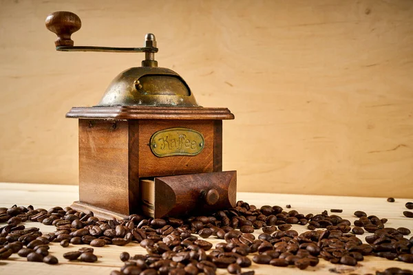 Moedor de café velho em uma mesa de madeira com sementes — Fotografia de Stock