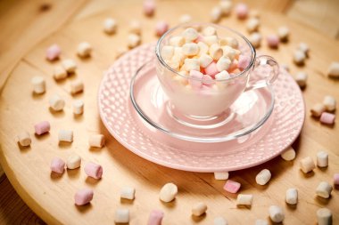 Ahşap masada sıcak süt ve renkli marshmallows ile Fincan