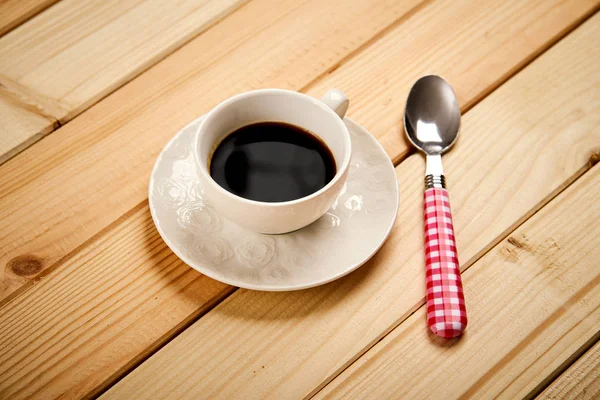 Copo branco com café preto aromático na mesa de madeira — Fotografia de Stock