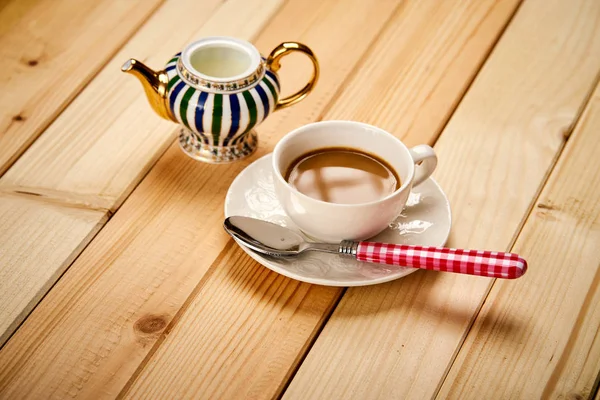 Xícara pequena com café aromático com leite na mesa de madeira — Fotografia de Stock