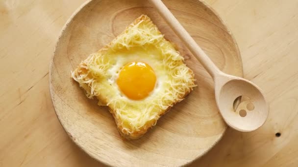 Vue du dessus du pain grillé avec oeuf frit et fromage sur une table de cuisine en bois — Video