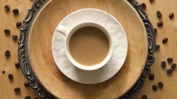 Top view of coffee with milk on decorative plate on wooden table — Stock Video