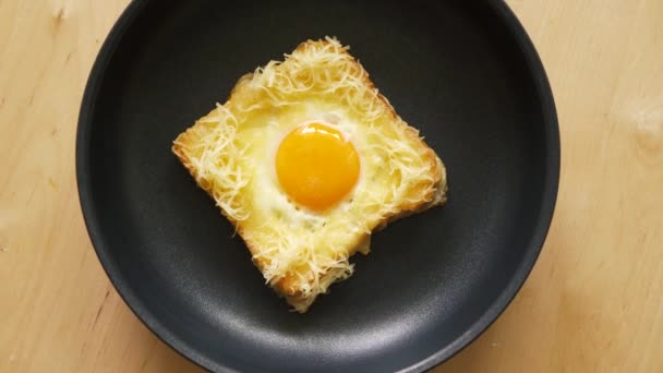 Top uitzicht van Toast met gebakken ei in pan op houten keuken tafel — Stockvideo