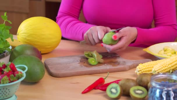 Mulher de blusa rosa cortando suculento Verde Kiwi — Vídeo de Stock