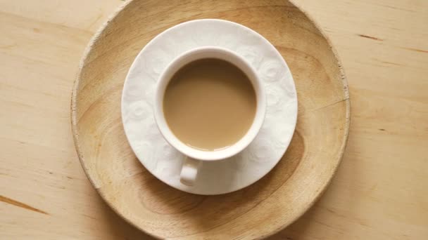 Vista superior da xícara com café aromático com leite na mesa de madeira — Vídeo de Stock