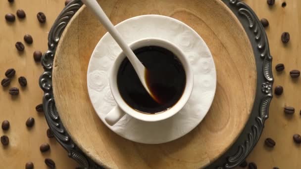 Vista superior de café con cuchara en plato decorativo sobre mesa de madera — Vídeos de Stock
