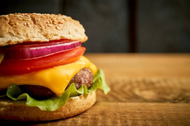Lezzetli hamburgerleri ahşap masa ve siyah arka planda yakın plan