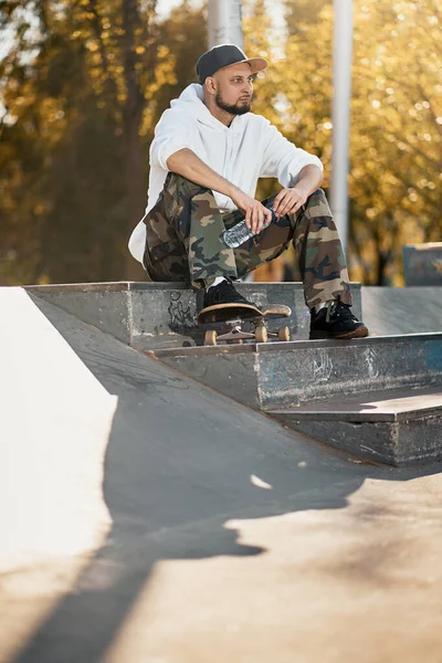 Mężczyzna w skateparku z deskorolką w ciepły jesienny dzień — Zdjęcie stockowe