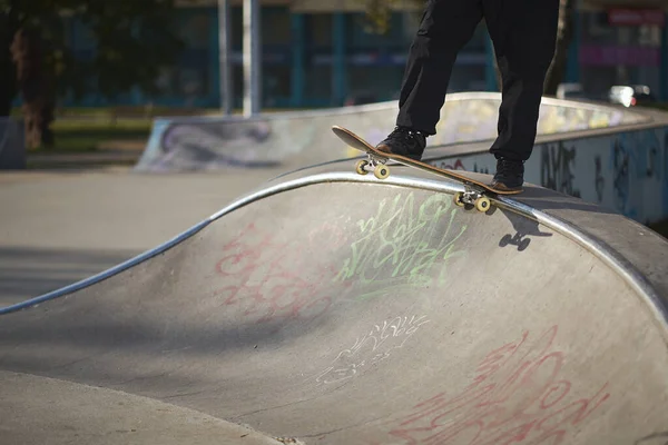 Uomo in skatepark cavalca skateboard nella calda giornata autunnale — Foto Stock