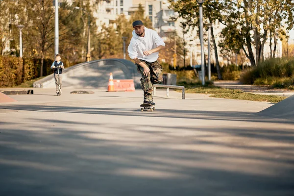 Uomo in skatepark cavalca skateboard nella calda giornata autunnale — Foto Stock