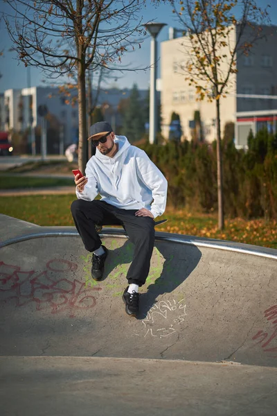 Skater ősszel a skateparkban beszél telefonon — Stock Fotó