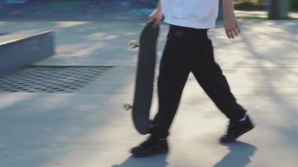 Крупный план ног скейтбордистов в бетонном скейтпарке осенью — стоковое видео