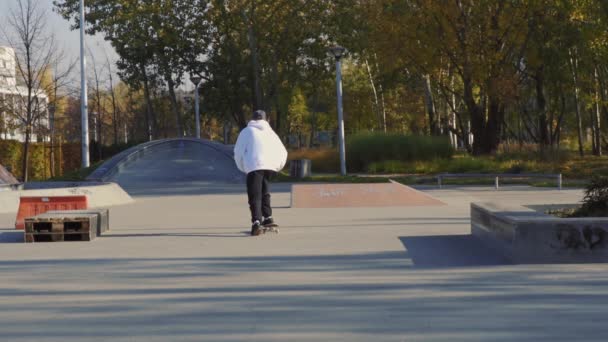 Skateboarder rijdt skateboard in skatepark op herfstdag — Stockvideo