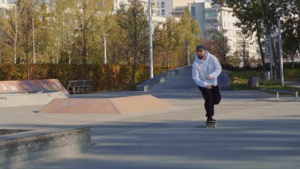 Skateboarder rides skateboard in skatepark on autumn day — Stock Video