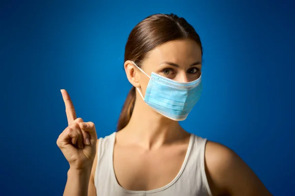 Femme en chemise blanche montre comment porter un masque lors d'une pandémie — Photo
