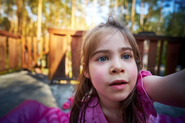 Çam ormanının terasında güzel küçük bir kız. — Stok fotoğraf