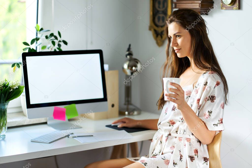 woman in pajamas working remotely at home during a pandemic