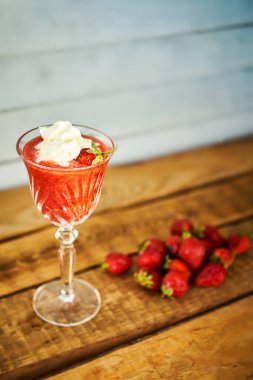 Eski bir köy masasında taze çilekli kokteyl.