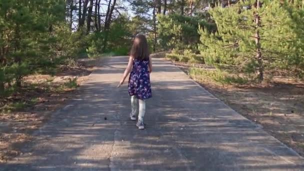 Dziewczyna w letniej sukience biegnie w sosnowym lesie — Wideo stockowe