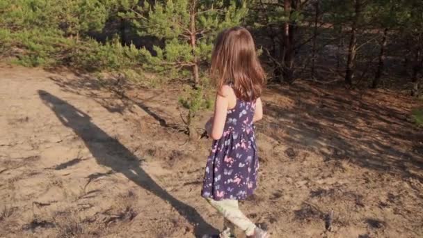 Dziewczyna w letniej sukience biegnie w sosnowym lesie — Wideo stockowe