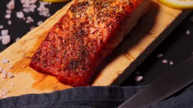 Mutfaktaki siyah tabakta lezzetli pişmiş altın somon balığı.