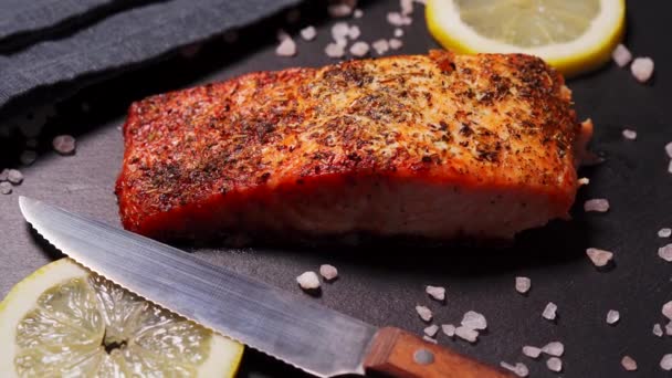 Delicioso salmão dourado assado em uma placa preta na cozinha — Vídeo de Stock