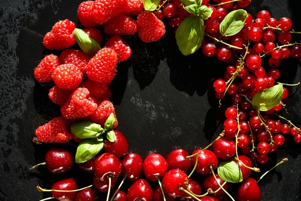 Вкусная и сочная красная малина и вишня на черном столе — стоковое фото