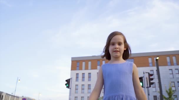 Bonito menina passa sobre as pistas na rua na cidade — Vídeo de Stock