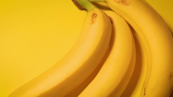 Свежие бананы на жёлтом минималистичном фоне — стоковое видео