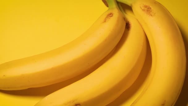 Bananas frescas em um fundo minimalista amarelo — Vídeo de Stock